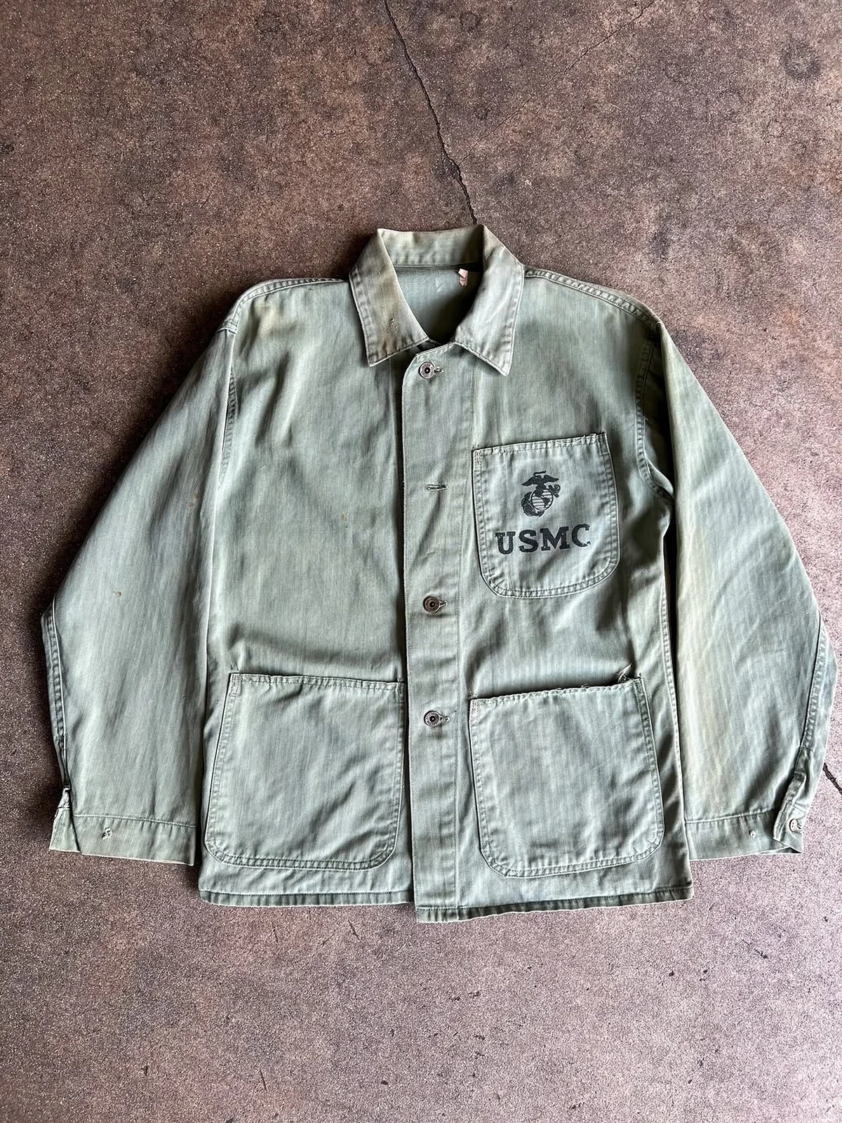 Green military utility garment with pocket and markings